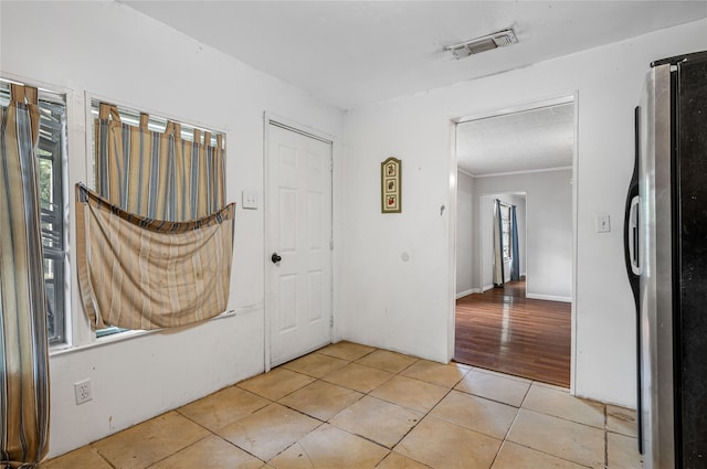 interior space with light hardwood / wood-style flooring and ornamental molding