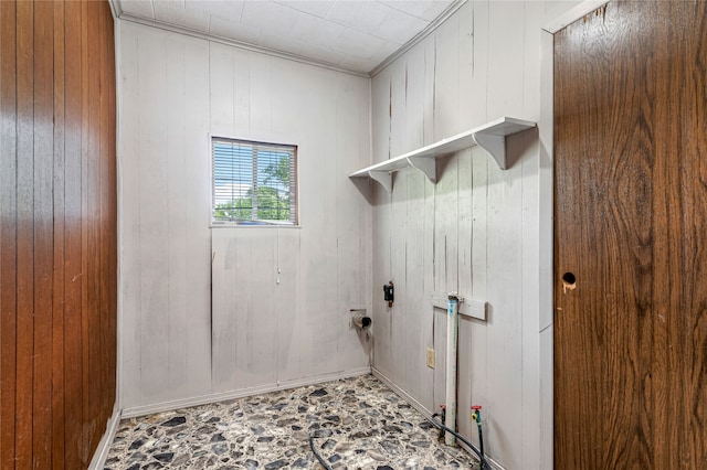 clothes washing area featuring wooden walls