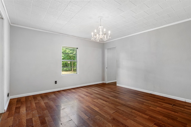 empty room featuring ornamental molding, dark wood-type flooring, and a notable chandelier