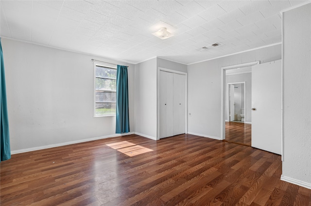 unfurnished bedroom with dark hardwood / wood-style floors and a closet