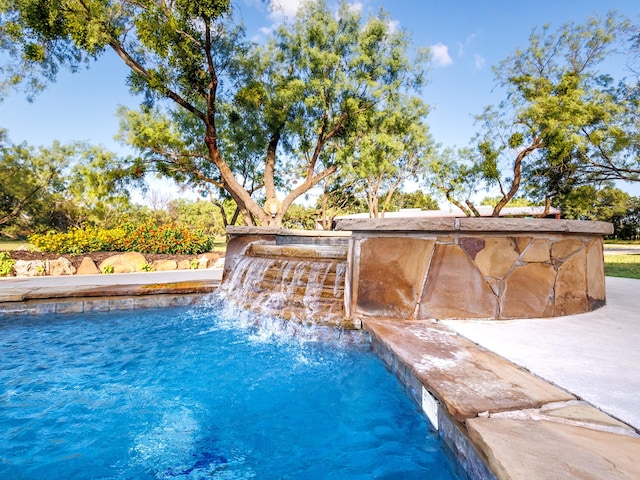 view of swimming pool with pool water feature