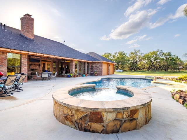 view of swimming pool with an in ground hot tub and a patio