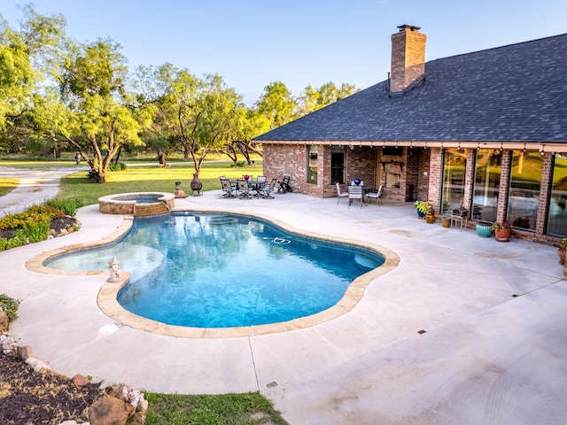 view of pool featuring a patio area and an in ground hot tub