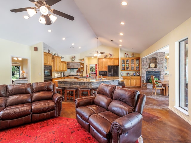 living room featuring lofted ceiling, ceiling fan, and a fireplace