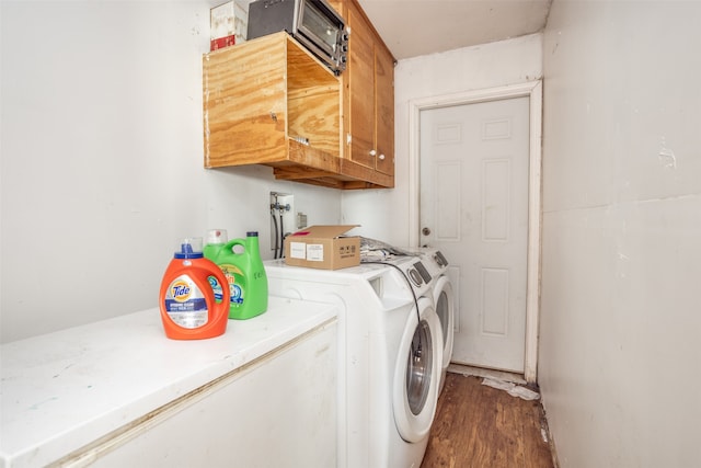 washroom with hookup for a washing machine, washer and clothes dryer, hardwood / wood-style floors, and cabinets