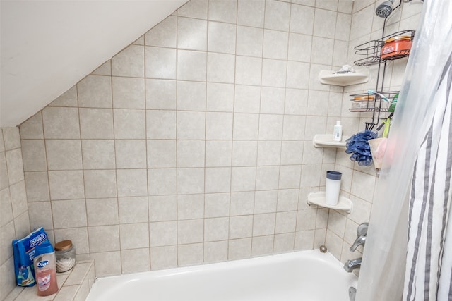 bathroom with lofted ceiling and shower / tub combo with curtain