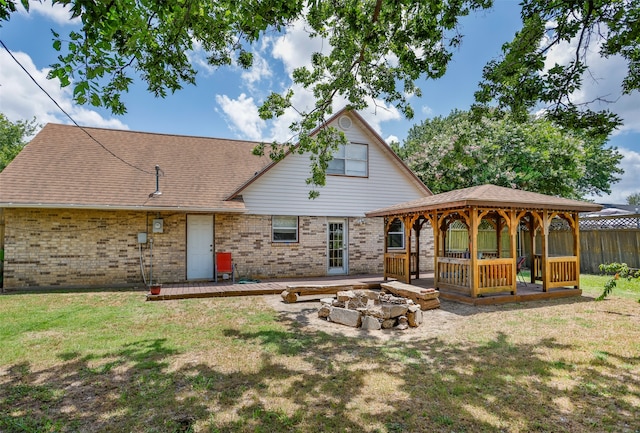 back of property featuring a gazebo, a yard, and an outdoor fire pit