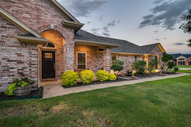 view of exterior entry with a yard