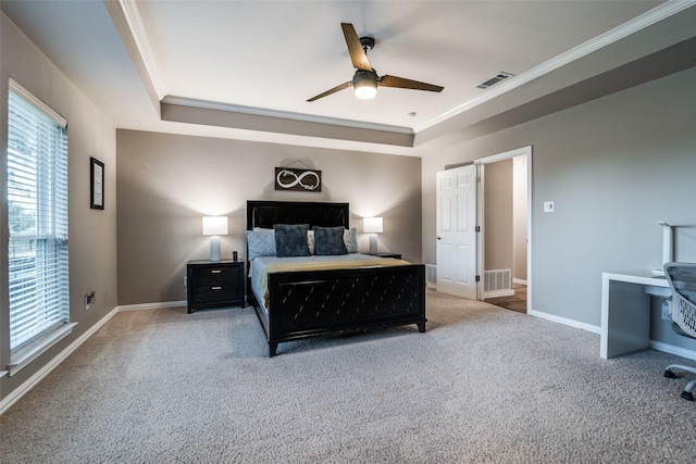 bedroom with ceiling fan, ornamental molding, a tray ceiling, and carpet floors