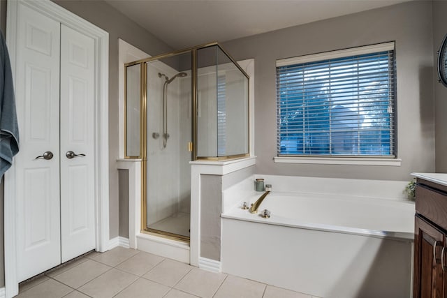 full bath with a stall shower, vanity, a bath, and tile patterned floors