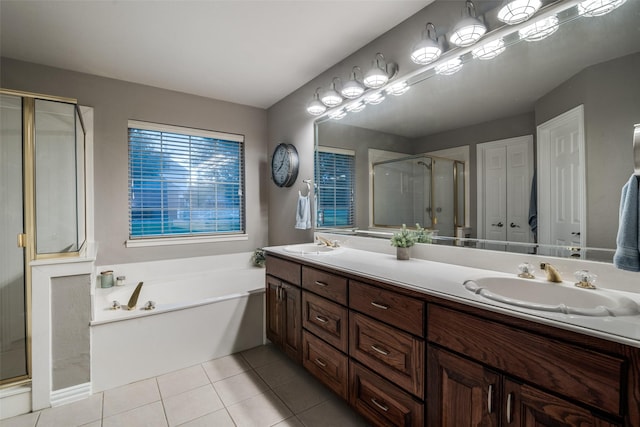 full bathroom with double vanity, a sink, a shower stall, and tile patterned floors