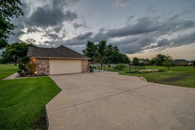 property exterior at dusk featuring a garage and a yard