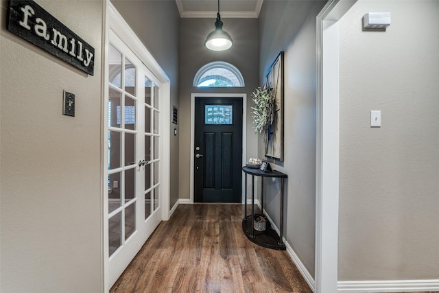 entryway featuring baseboards, dark wood finished floors, crown molding, and french doors