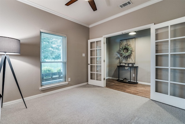 empty room featuring ceiling fan, carpet floors, visible vents, french doors, and crown molding