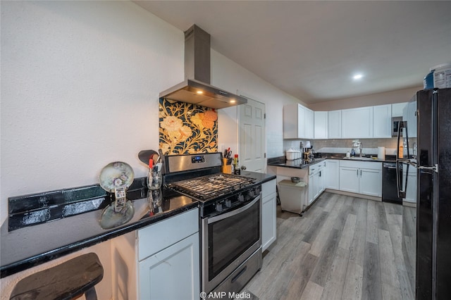 kitchen featuring light hardwood / wood-style flooring, white cabinetry, range hood, tasteful backsplash, and gas stove