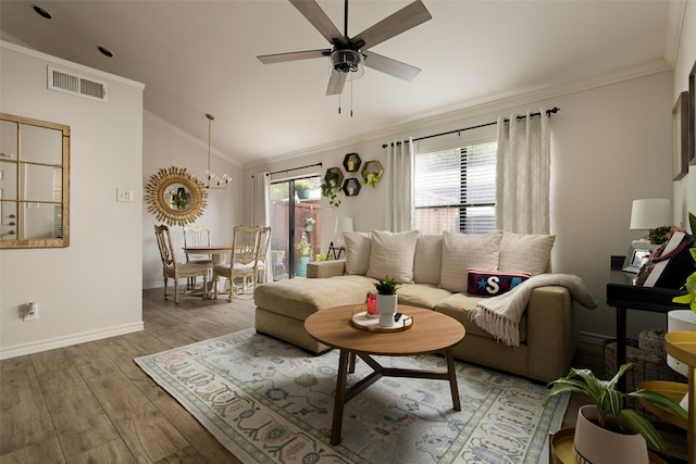 living room with light hardwood / wood-style flooring, ceiling fan with notable chandelier, lofted ceiling, and ornamental molding