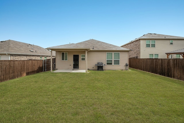 rear view of house featuring a yard and a patio