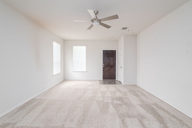 interior space featuring a closet, light colored carpet, a spacious closet, and ceiling fan