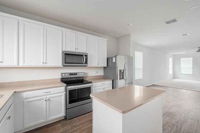 kitchen with a center island, light hardwood / wood-style flooring, appliances with stainless steel finishes, white cabinetry, and ceiling fan