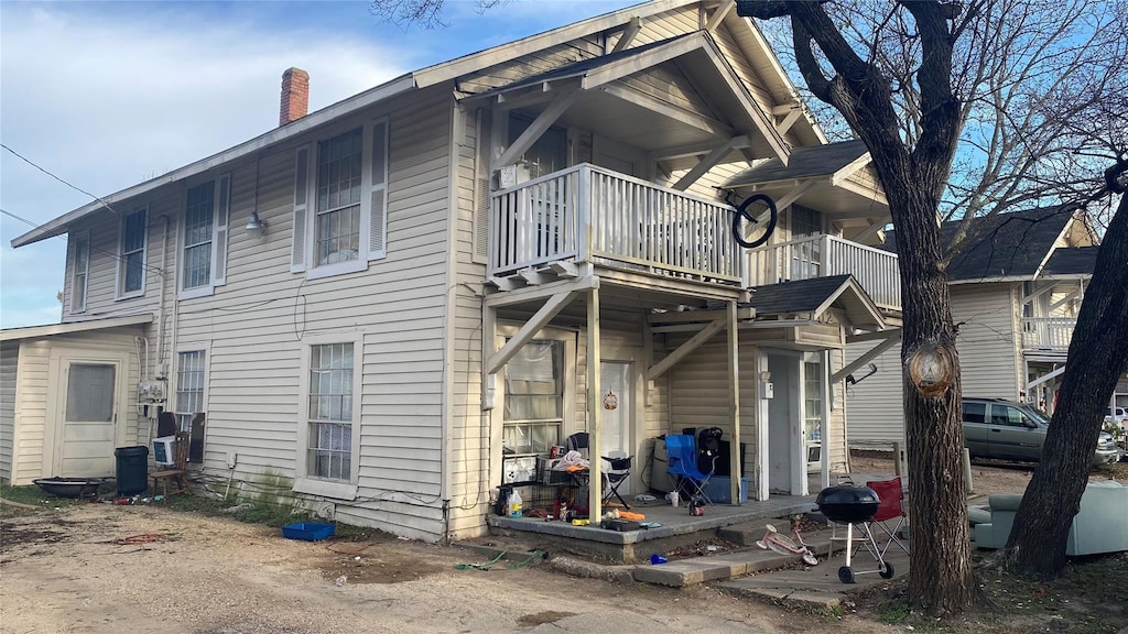 800 N Sherman St, Ennis, TX 75119 - back of house featuring a balcony and a chimney