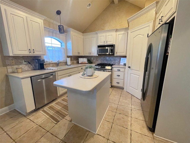 kitchen featuring stainless steel appliances, a kitchen island, light countertops, and decorative backsplash