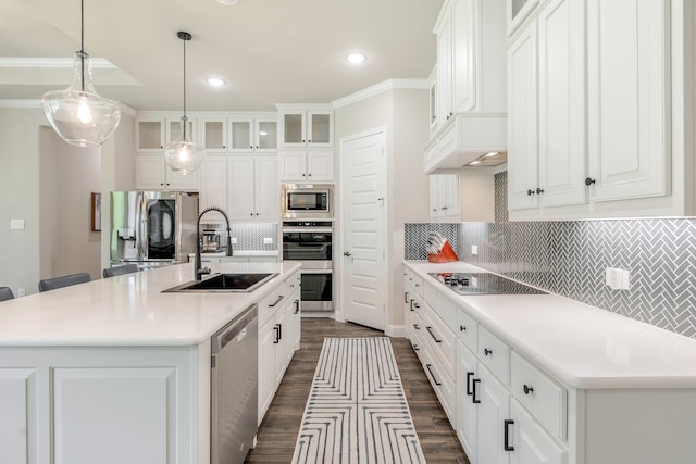 kitchen featuring backsplash, stainless steel appliances, sink, a center island with sink, and white cabinets