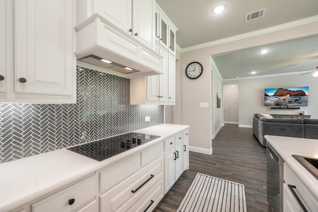 kitchen featuring backsplash, white cabinetry, black electric stovetop, and ornamental molding