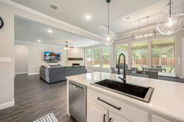 kitchen featuring stainless steel dishwasher, pendant lighting, white cabinetry, and sink