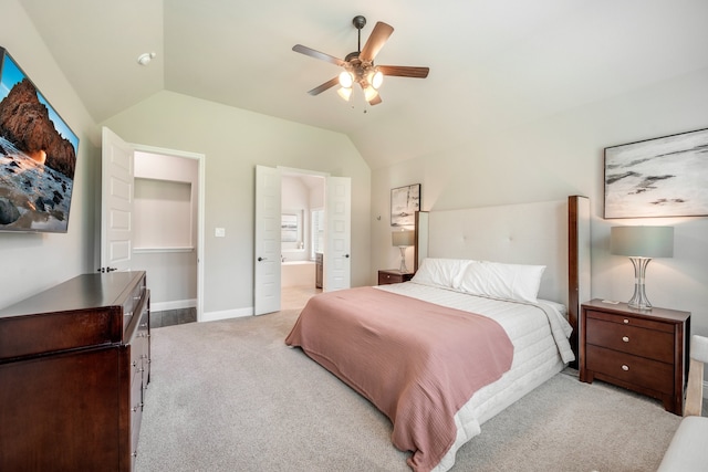 bedroom featuring light carpet, ensuite bathroom, ceiling fan, and lofted ceiling