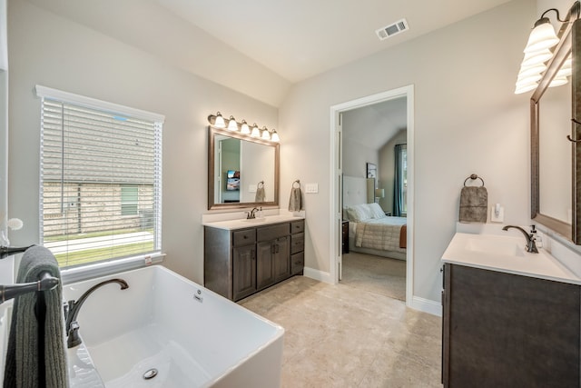 bathroom with a bath, vanity, and lofted ceiling