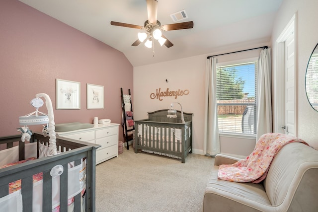 carpeted bedroom with vaulted ceiling, a nursery area, and ceiling fan