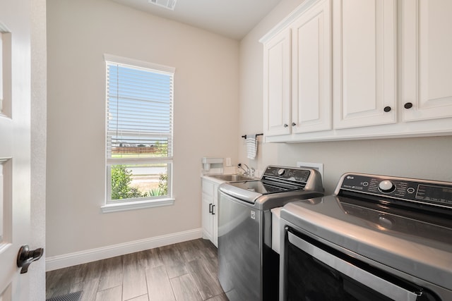 washroom featuring cabinets, dark hardwood / wood-style flooring, separate washer and dryer, and sink