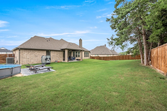 view of yard featuring a fenced in pool, a patio area, and cooling unit