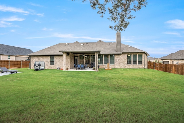 back of property featuring ceiling fan, a patio area, and a yard