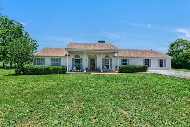 view of front of house with a porch, a front yard, and brick siding