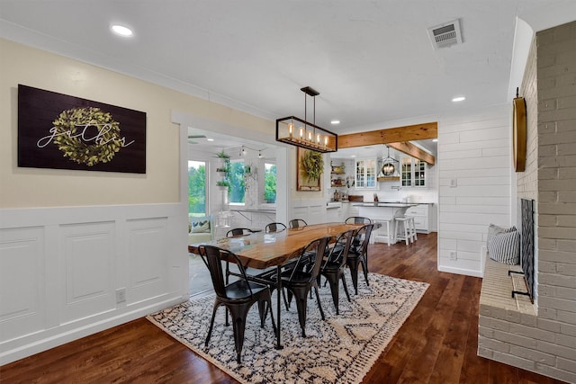 dining space with dark wood-type flooring, a brick fireplace, visible vents, and recessed lighting