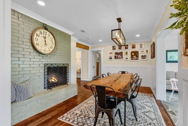 dining space with crown molding, dark hardwood / wood-style floors, and a fireplace