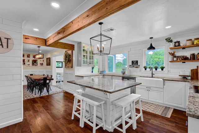 kitchen with dark wood-style floors, beamed ceiling, visible vents, and white cabinetry