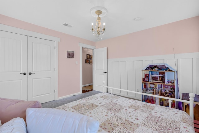 bedroom featuring a closet, carpet floors, and an inviting chandelier