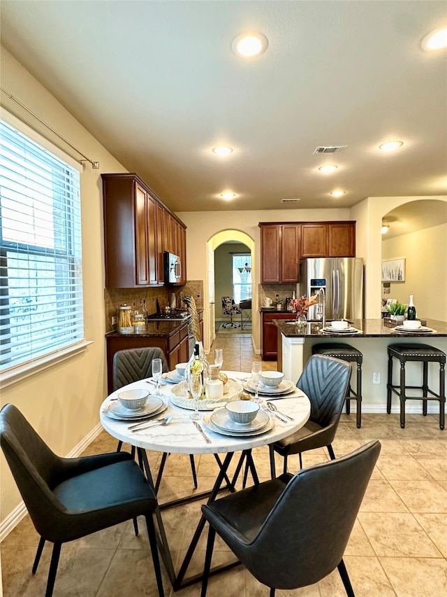 tiled dining room with a healthy amount of sunlight