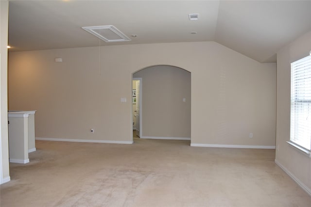 carpeted empty room featuring lofted ceiling