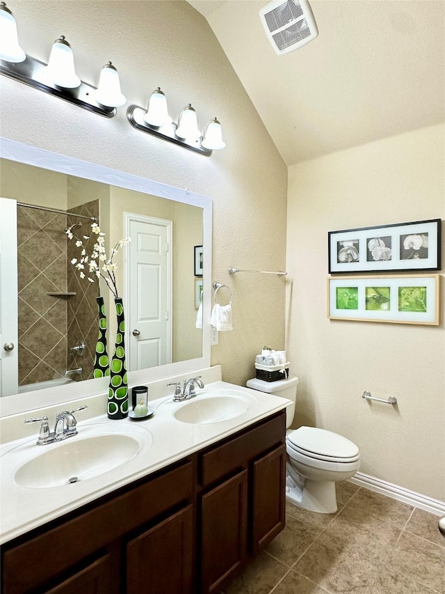 bathroom featuring tile patterned floors, vanity, toilet, and lofted ceiling