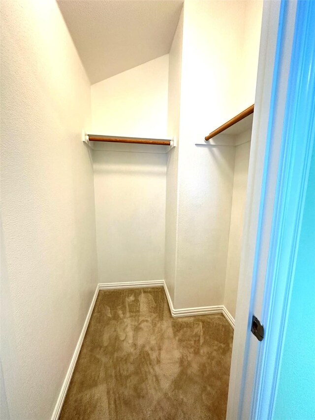 spacious closet featuring dark colored carpet