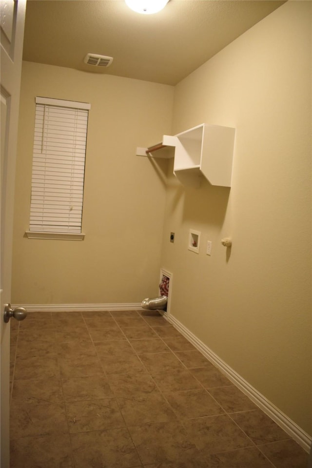 laundry room with dark tile patterned flooring, electric dryer hookup, and hookup for a washing machine