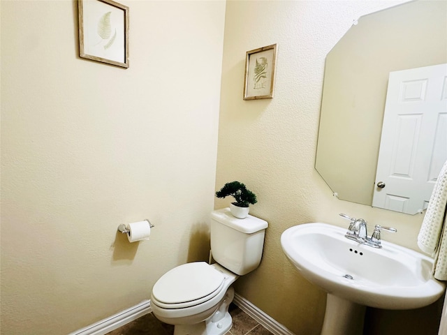 bathroom featuring tile patterned flooring, toilet, and sink