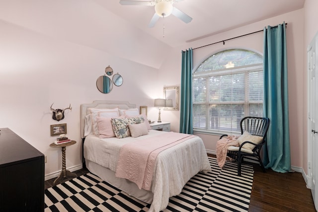 bedroom with ceiling fan, vaulted ceiling, baseboards, and wood finished floors