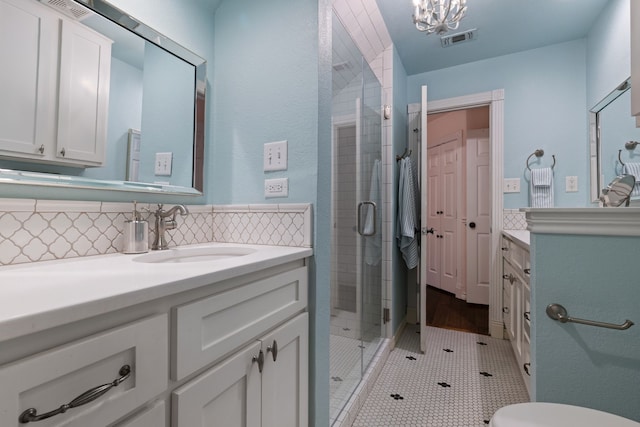 full bathroom with a stall shower, vanity, visible vents, and decorative backsplash