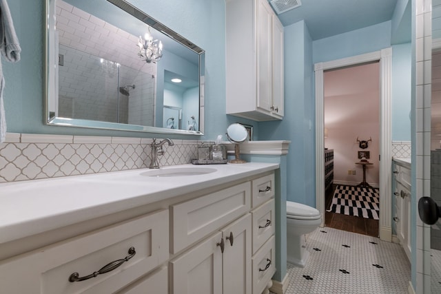 bathroom featuring visible vents, tiled shower, toilet, tile patterned flooring, and vanity