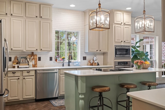 kitchen with a chandelier, stainless steel appliances, a sink, and light countertops