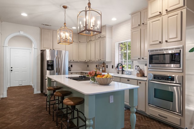 kitchen with visible vents, a kitchen island, stainless steel appliances, light countertops, and a sink